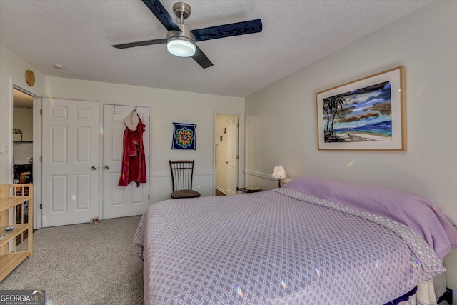 bedroom featuring a closet, light colored carpet, ceiling fan, and a textured ceiling