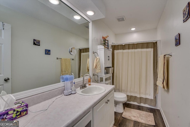 full bathroom with visible vents, toilet, shower / tub combo with curtain, wood finished floors, and vanity