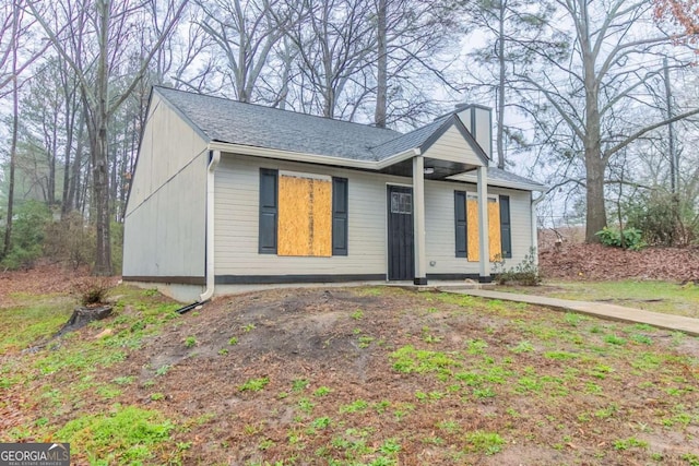 ranch-style home with roof with shingles