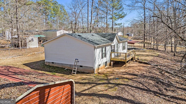 view of side of home with crawl space and roof with shingles