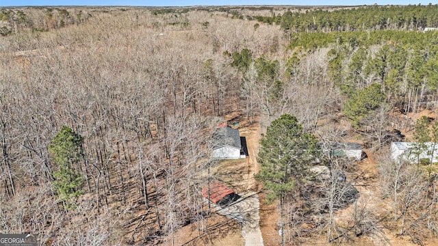 drone / aerial view featuring a wooded view