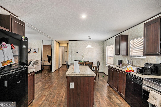 kitchen featuring a sink, hanging light fixtures, light countertops, a center island, and black appliances