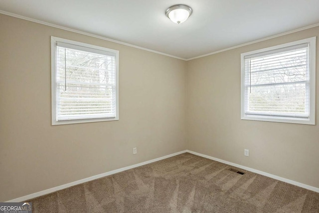 carpeted spare room with visible vents, crown molding, and baseboards