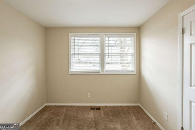 carpeted spare room with baseboards and visible vents