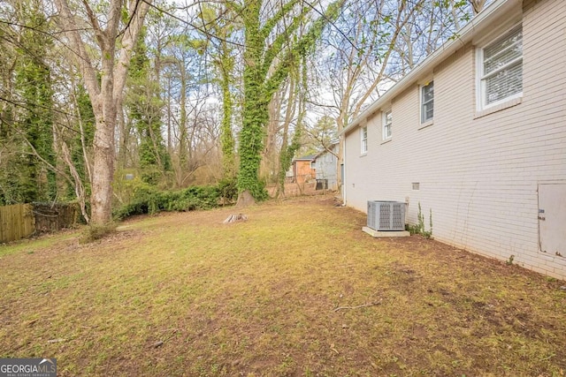 view of yard with fence and central air condition unit