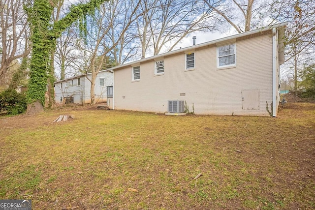 back of property with crawl space, brick siding, a yard, and central AC unit