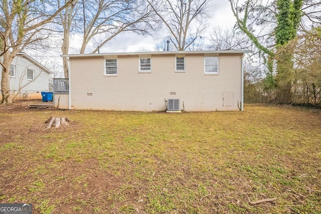 back of house with a yard, central AC, brick siding, and crawl space