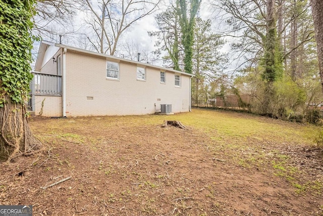 back of property with crawl space, brick siding, and central AC unit