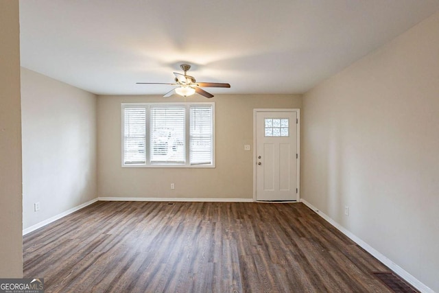 foyer entrance with dark wood-style floors, ceiling fan, visible vents, and baseboards