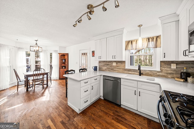 kitchen with a peninsula, a sink, light countertops, and stainless steel appliances