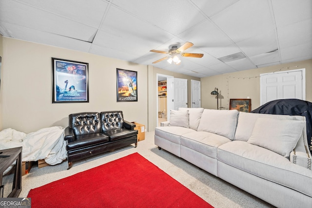 carpeted living room with a ceiling fan and a paneled ceiling