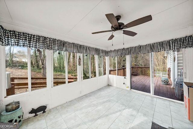 unfurnished sunroom with a healthy amount of sunlight and a ceiling fan