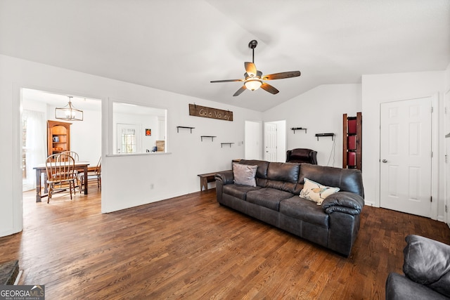 living area featuring ceiling fan with notable chandelier, lofted ceiling, and wood finished floors