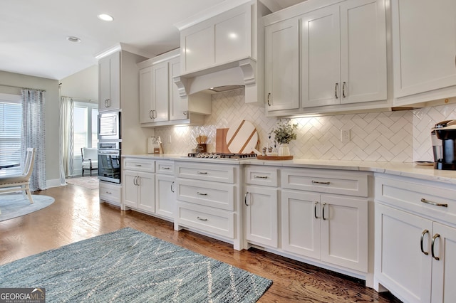 kitchen featuring appliances with stainless steel finishes, light stone counters, white cabinetry, backsplash, and recessed lighting