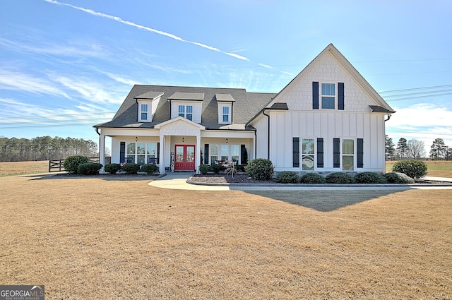 modern farmhouse style home featuring a front lawn, board and batten siding, and french doors