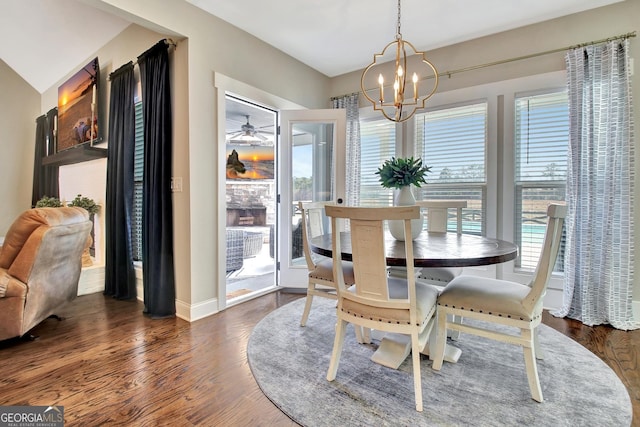 dining area with dark wood-style floors, a notable chandelier, and baseboards