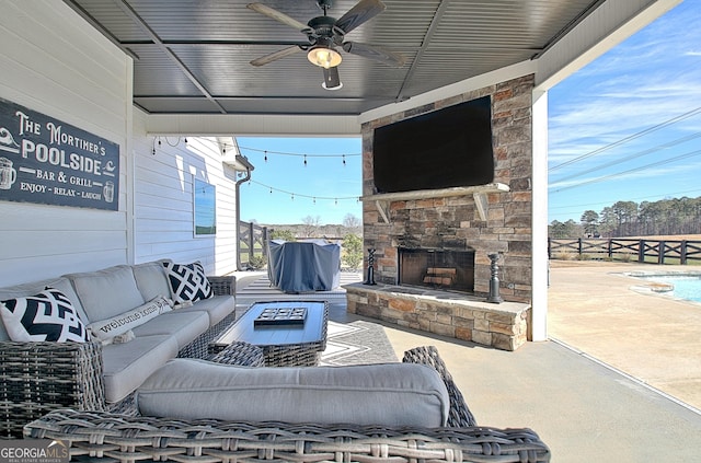 view of patio with ceiling fan, an outdoor living space with a fireplace, and fence