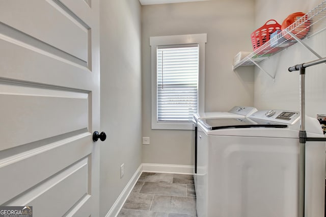 laundry room with laundry area, washing machine and dryer, and baseboards