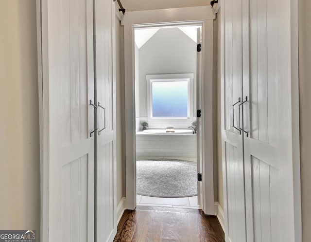 hall featuring dark wood-type flooring and a barn door