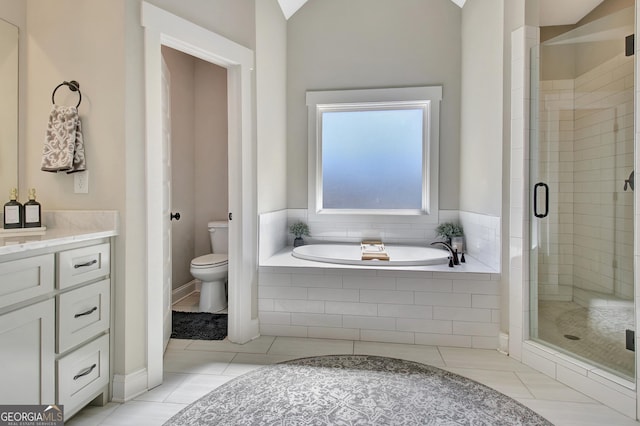 full bath featuring a stall shower, toilet, tile patterned floors, a garden tub, and vanity