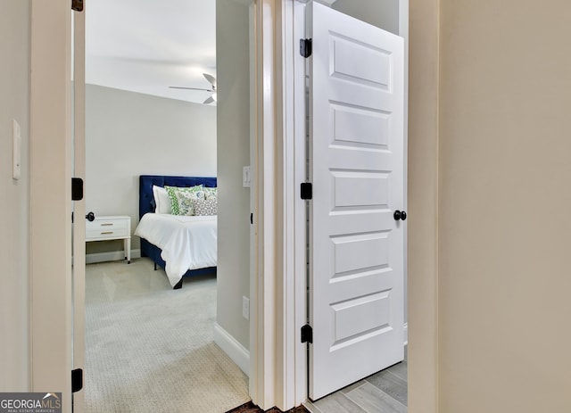 bedroom featuring light carpet and baseboards