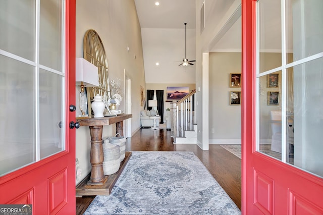 entrance foyer featuring ceiling fan, dark wood-type flooring, a high ceiling, baseboards, and stairway