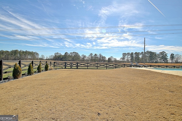 view of yard featuring a rural view and fence