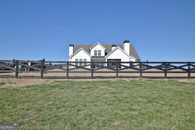 view of home's community with fence and a lawn