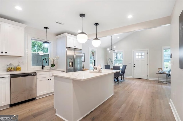 kitchen with a center island, visible vents, appliances with stainless steel finishes, white cabinets, and a sink