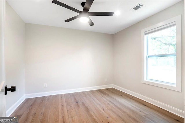 spare room with light wood-type flooring, baseboards, visible vents, and a ceiling fan