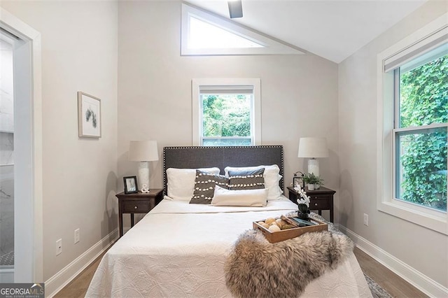 bedroom featuring vaulted ceiling, dark wood-style flooring, multiple windows, and baseboards