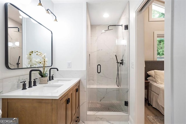 bathroom with a marble finish shower, a sink, and ensuite bath