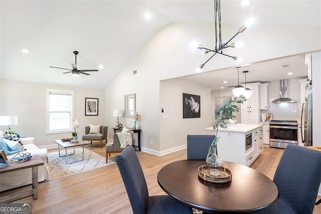 dining room with a ceiling fan, light wood-style flooring, high vaulted ceiling, and baseboards