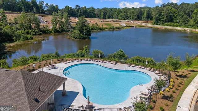 pool featuring a water view, fence, and a patio