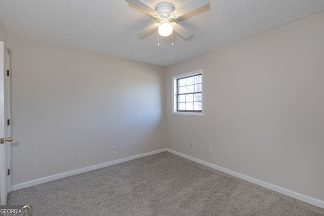 carpeted spare room featuring ceiling fan, a textured ceiling, and baseboards