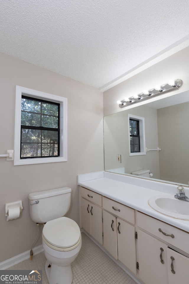 bathroom featuring a textured ceiling, toilet, tile patterned flooring, and vanity