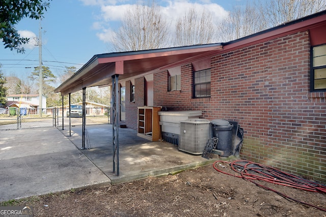 view of patio featuring a gate, central AC unit, and fence