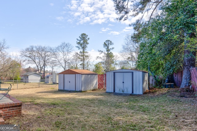 view of yard with an outbuilding, a fenced backyard, and a storage unit