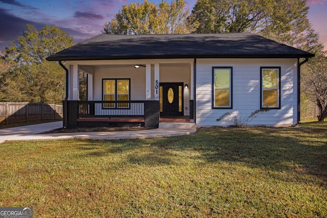 view of front of property featuring a porch, a front yard, and fence