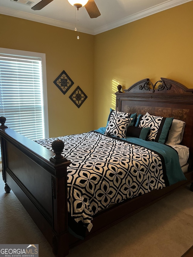 bedroom with carpet floors, visible vents, crown molding, and ceiling fan