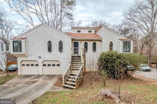 view of front of property featuring a garage, driveway, and stairway