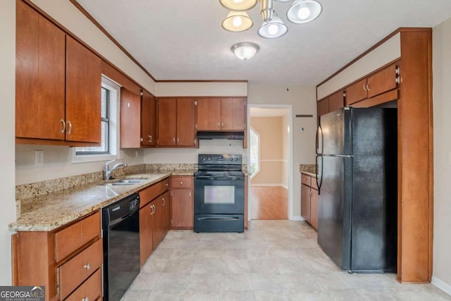 kitchen featuring black appliances, under cabinet range hood, brown cabinetry, and a sink