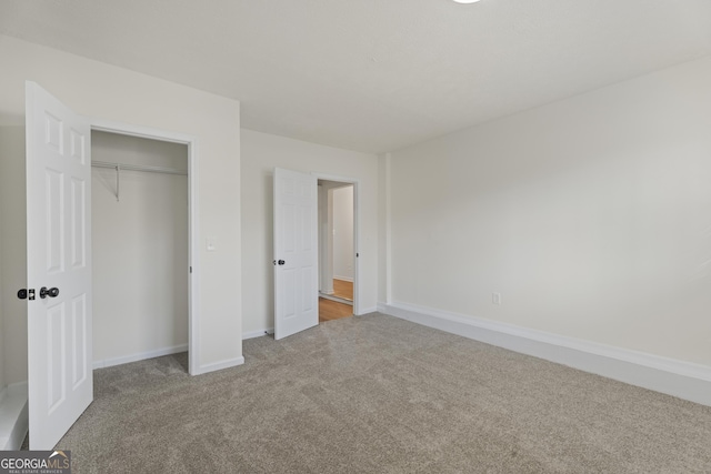 unfurnished bedroom featuring a closet, light carpet, and baseboards