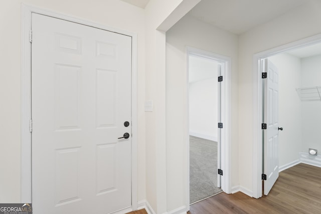 hall with baseboards and wood finished floors