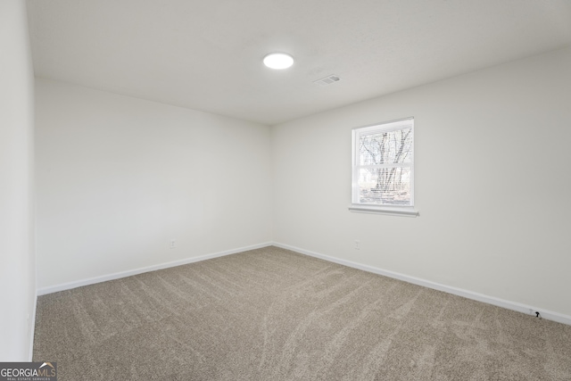 spare room with carpet and baseboards