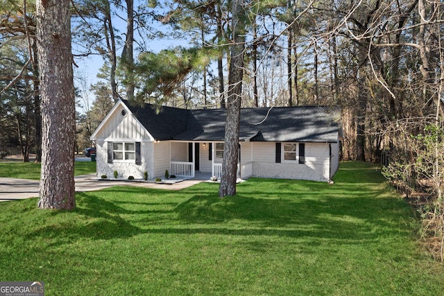 view of front of property with covered porch, a front lawn, and board and batten siding
