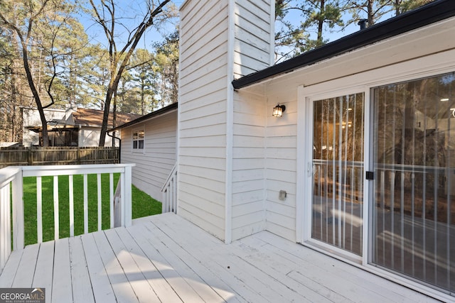 wooden deck featuring fence and a lawn