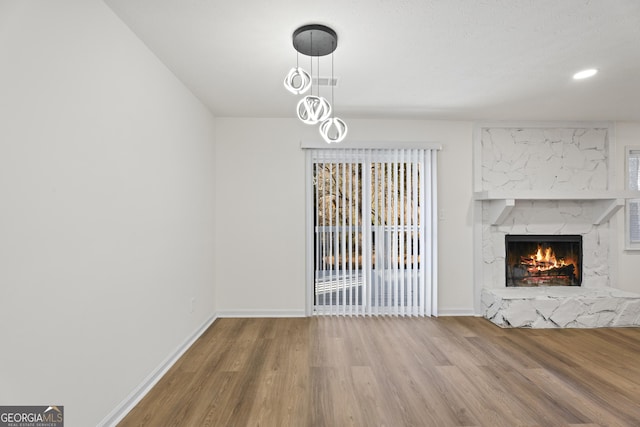 unfurnished living room featuring a fireplace, wood finished floors, and baseboards