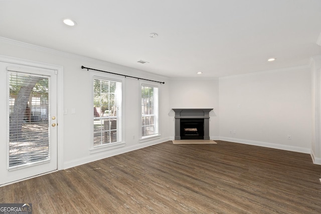 unfurnished living room with crown molding, a fireplace, baseboards, and dark wood-type flooring