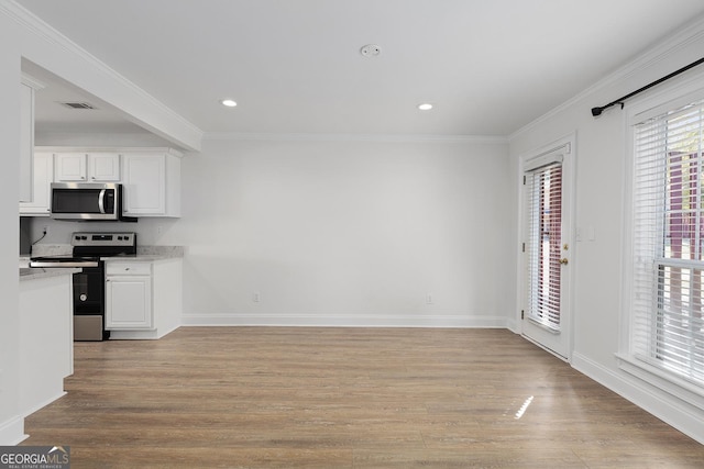 kitchen with stainless steel appliances, visible vents, white cabinetry, light wood-style floors, and ornamental molding